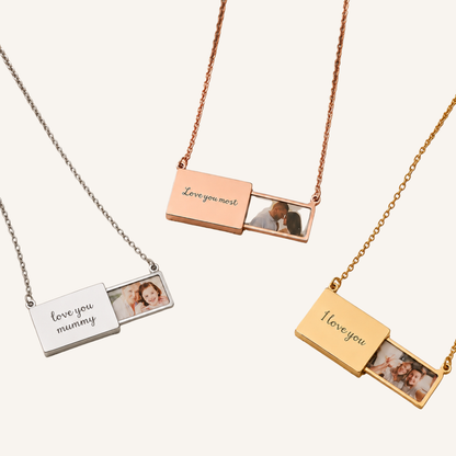 Three photo slide necklace pendants in silver, rose gold, and yellow gold, each with a sliding compartment showing a custom photo and engraved with sentiments like 'love you mum', 'love you most', and 'I love you'.